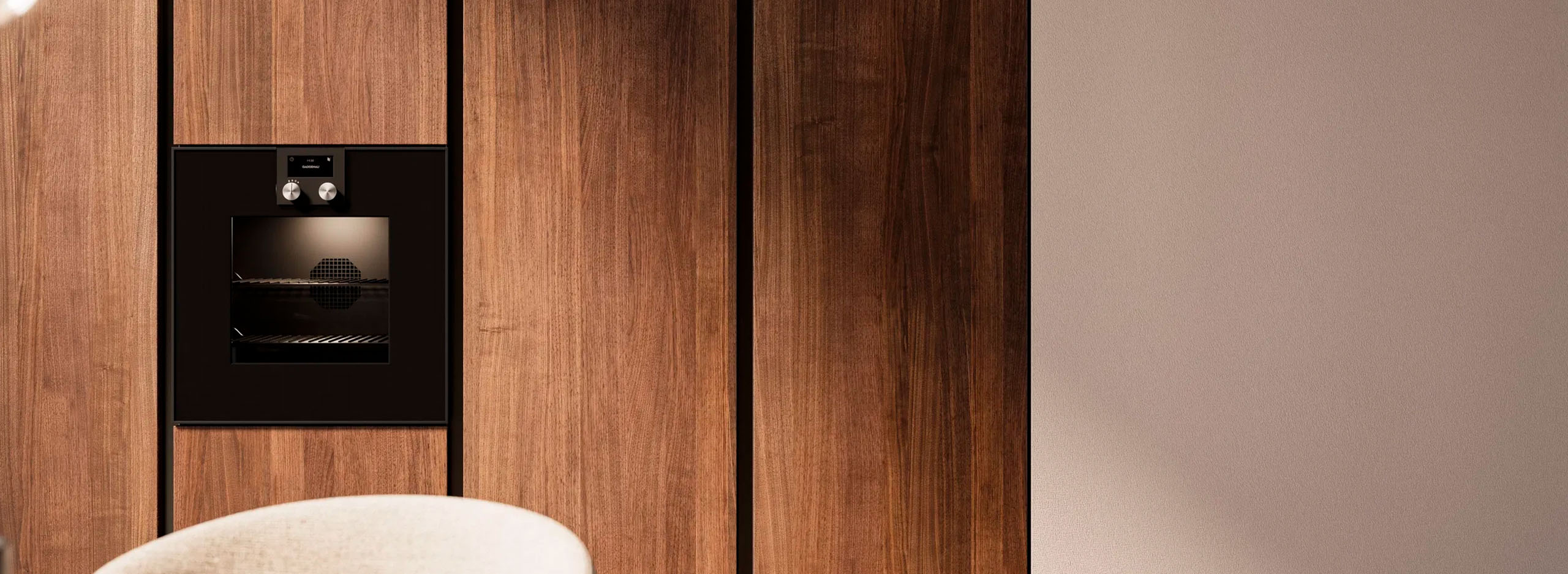 Küchenfront in Holz und Beige mit dezent eingebauten Backofen.