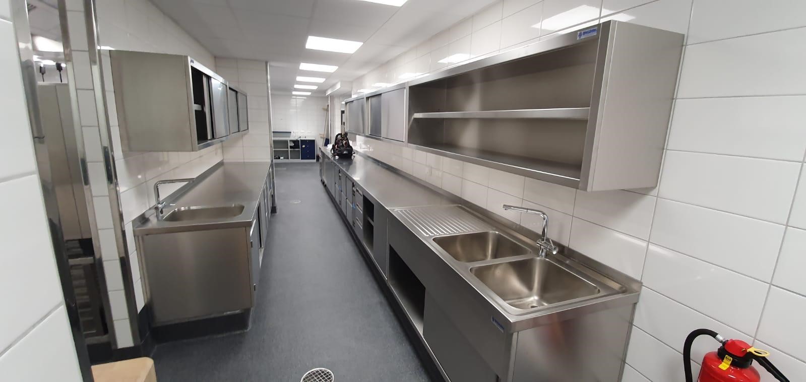 Edelstahl-Gewerbeküche mit zwei gegenüberliegenden Küchenzeilen, geplant von Heiser's Küchen.