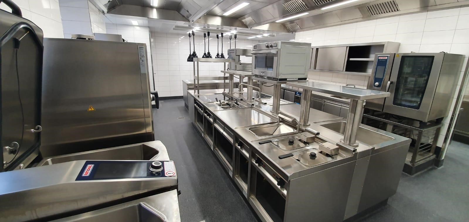 Von Heiser's Küchen geplante Edelstahl-Gewerbeküche mit zentraler, großzügiger Kochinsel