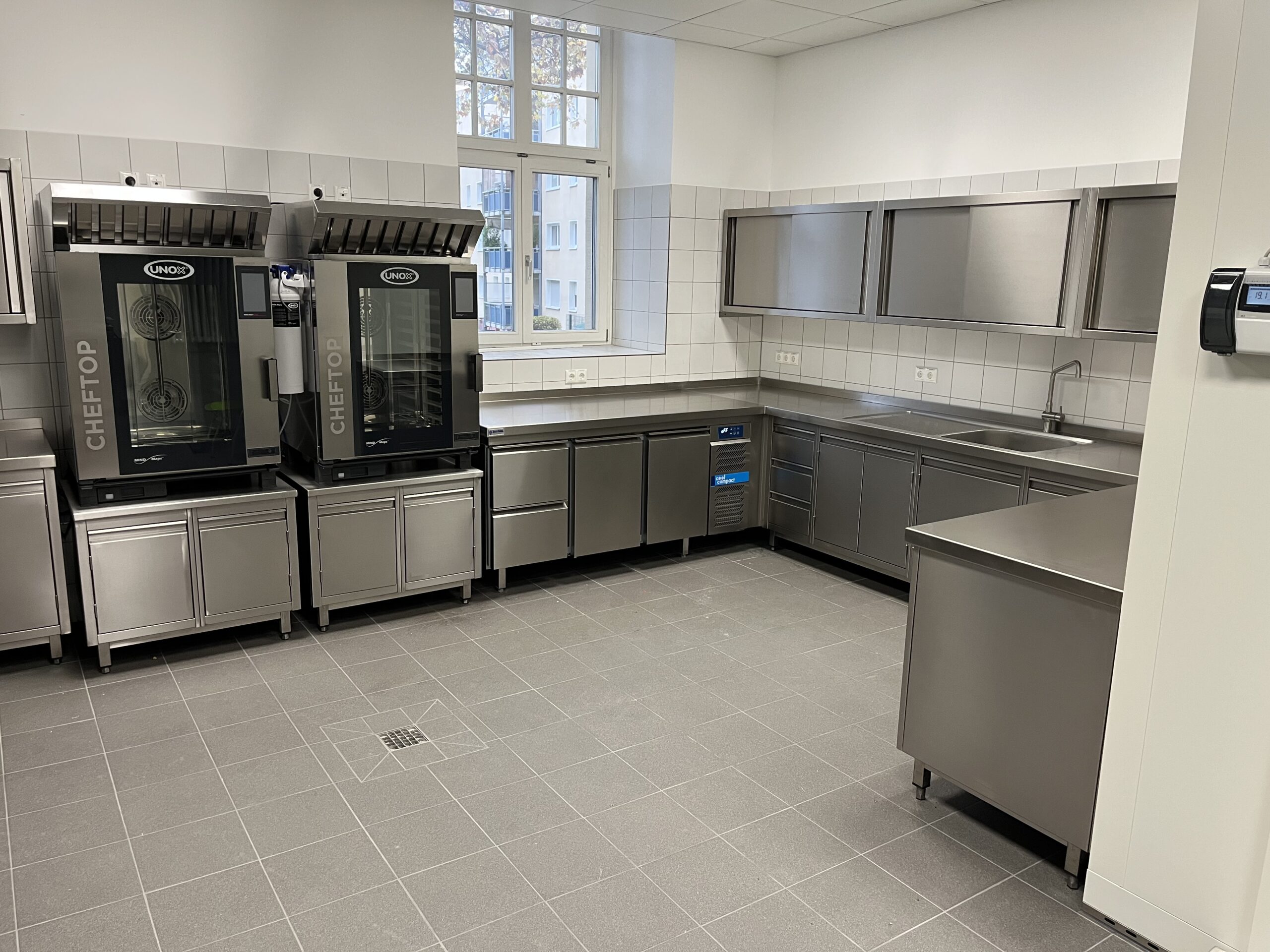 Edelstahl-Gewerbeküche mit Spülmaschinen, großem Spülbecken, viel Arbeitsfläche und Stauraum – Referenz von Heiser's Küchen.